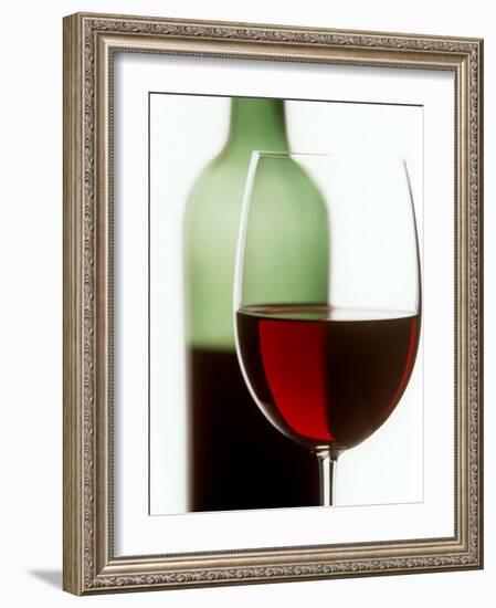 Red Wine Glass with Half-Full Wine Bottle in Background-Joerg Lehmann-Framed Photographic Print