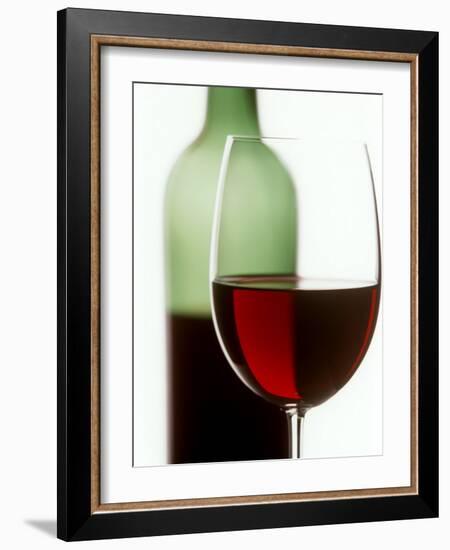 Red Wine Glass with Half-Full Wine Bottle in Background-Joerg Lehmann-Framed Photographic Print