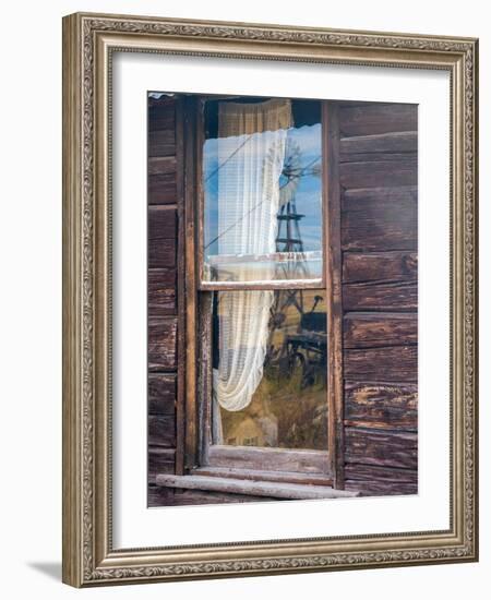 Reflection of the windmill and tractor in the window of an old building in ghost town.-Julie Eggers-Framed Photographic Print