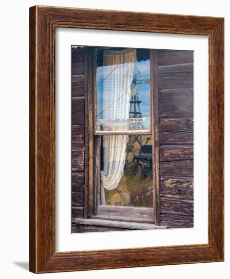 Reflection of the windmill and tractor in the window of an old building in ghost town.-Julie Eggers-Framed Photographic Print