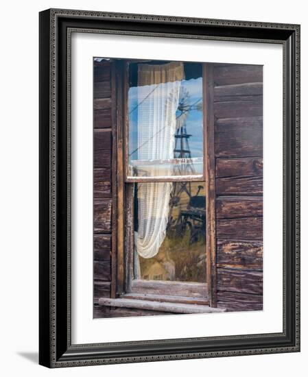 Reflection of the windmill and tractor in the window of an old building in ghost town.-Julie Eggers-Framed Photographic Print