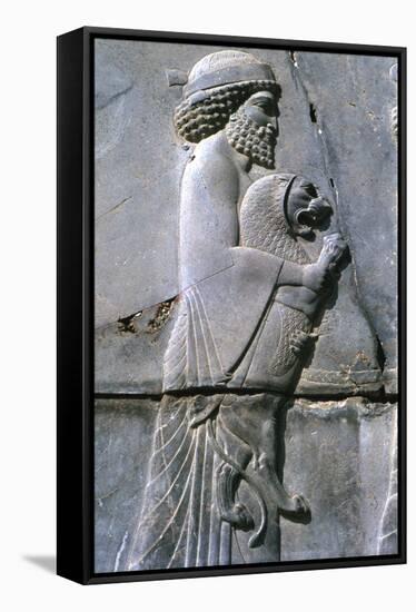 Relief of a man holding a lion cub, Persepolis, Iran-Vivienne Sharp-Framed Stretched Canvas