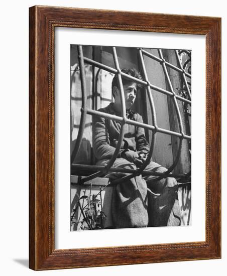 Resident of Italian Boystown Sitting in Barred Windowsill as Punishment For Wasting Bread-Hans Wild-Framed Photographic Print