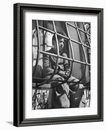 Resident of Italian Boystown Sitting in Barred Windowsill as Punishment For Wasting Bread-Hans Wild-Framed Photographic Print