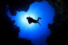 Scuba Divers Descend into an Underwater Cavern. Silhouettes against Sunburst-Rich Carey-Photographic Print