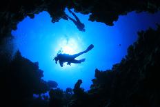 Scuba Divers Descend into an Underwater Cavern. Silhouettes against Sunburst-Rich Carey-Photographic Print