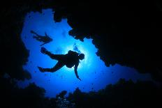 Scuba Divers Descend into an Underwater Cavern. Silhouettes against Sunburst-Rich Carey-Photographic Print