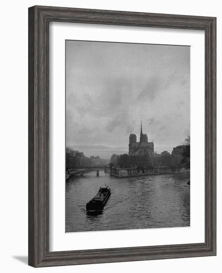 River Barge Churning up the Seine Past Notre Dame Cathedral on a Gloomy Winter Day-Ed Clark-Framed Photographic Print