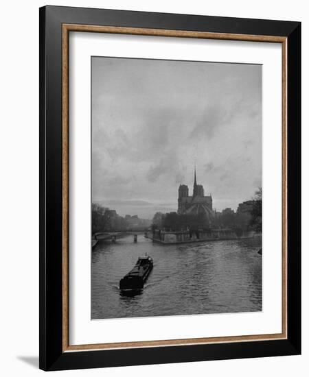 River Barge Churning up the Seine Past Notre Dame Cathedral on a Gloomy Winter Day-Ed Clark-Framed Photographic Print