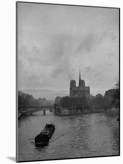 River Barge Churning up the Seine Past Notre Dame Cathedral on a Gloomy Winter Day-Ed Clark-Mounted Photographic Print