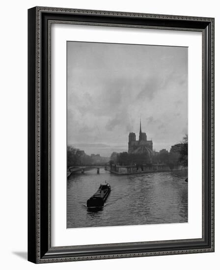 River Barge Churning up the Seine Past Notre Dame Cathedral on a Gloomy Winter Day-Ed Clark-Framed Photographic Print