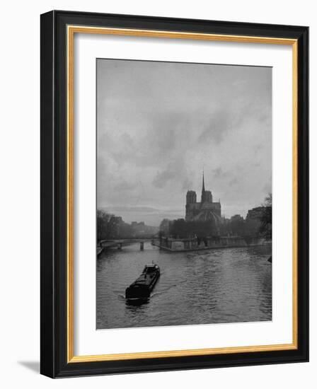 River Barge Churning up the Seine Past Notre Dame Cathedral on a Gloomy Winter Day-Ed Clark-Framed Photographic Print