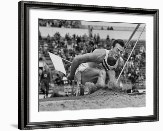 Robert B. Mathias Grimacing with the Effort of His 22 Foot 11 Inch Leap at 1952 Olympics-Mark Kauffman-Framed Premium Photographic Print