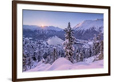 Sunrise over village and Lake of St. Moritz covered with