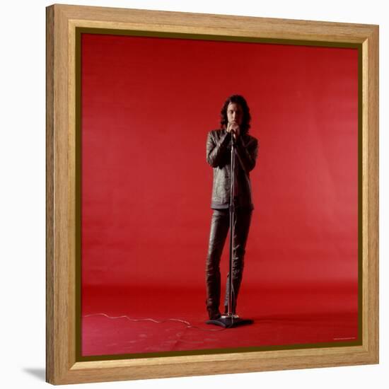 Rock Star Jim Morrison of the Doors Holding Microphone Alone as He Stands Against a Red Backdrop-Yale Joel-Framed Premier Image Canvas