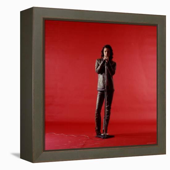 Rock Star Jim Morrison of the Doors Holding Microphone Alone as He Stands Against a Red Backdrop-Yale Joel-Framed Premier Image Canvas