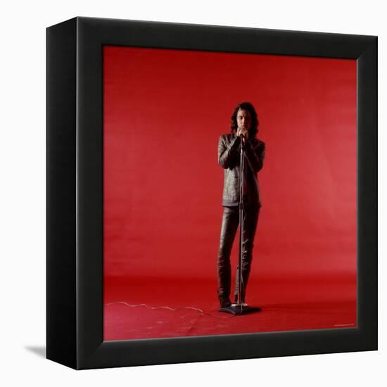 Rock Star Jim Morrison of the Doors Holding Microphone Alone as He Stands Against a Red Backdrop-Yale Joel-Framed Premier Image Canvas