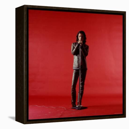 Rock Star Jim Morrison of the Doors Holding Microphone Alone as He Stands Against a Red Backdrop-Yale Joel-Framed Premier Image Canvas