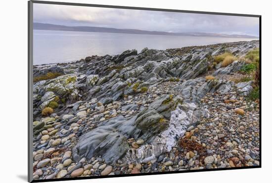 Rocky shore near Pirnmill looking out across the Kilbrannan Sound to Mull of Kintyre, Isle of Arran-Gary Cook-Mounted Photographic Print