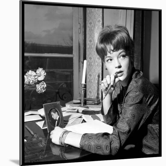 Romy Schneider, Thougthful, Trying to Write a Letter in Front of Alain Delon's Picture-Marcel Begoin-Mounted Photographic Print