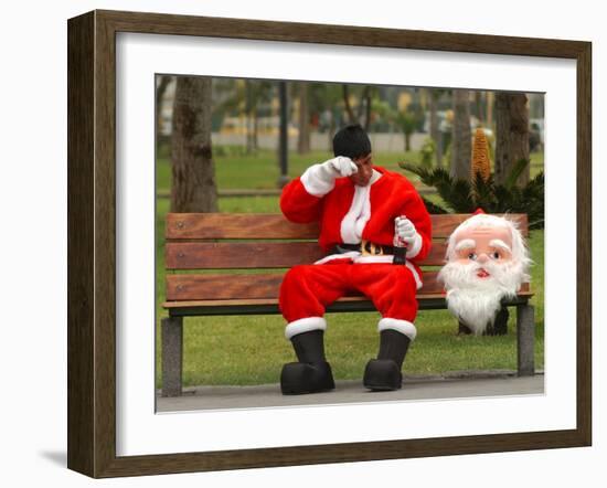 Ronald Guzman, Who Works as Santa Claus, Takes a Break in a Public Park in Lima, Peru-null-Framed Photographic Print