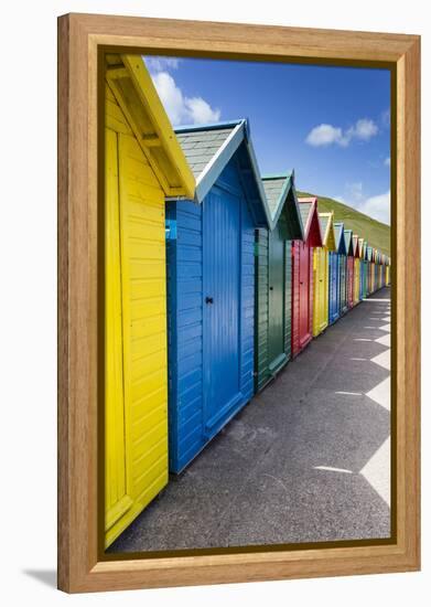 Row of Colourful Beach Huts and their Shadows with Green Hill Backdrop-Eleanor Scriven-Framed Premier Image Canvas