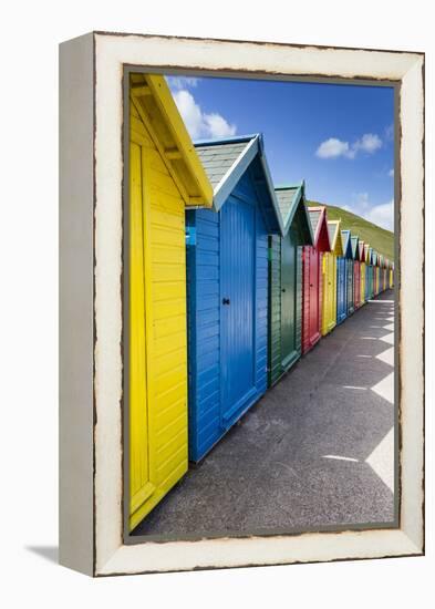 Row of Colourful Beach Huts and their Shadows with Green Hill Backdrop-Eleanor Scriven-Framed Premier Image Canvas