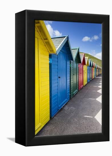 Row of Colourful Beach Huts and their Shadows with Green Hill Backdrop-Eleanor Scriven-Framed Premier Image Canvas