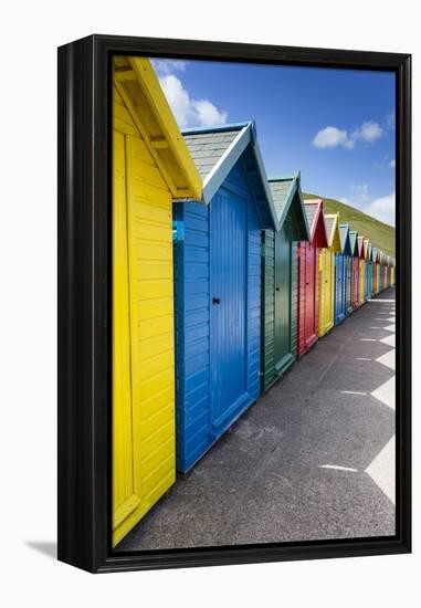 Row of Colourful Beach Huts and their Shadows with Green Hill Backdrop-Eleanor Scriven-Framed Premier Image Canvas