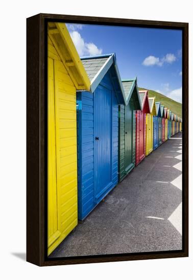 Row of Colourful Beach Huts and their Shadows with Green Hill Backdrop-Eleanor Scriven-Framed Premier Image Canvas