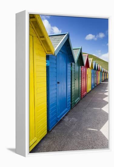 Row of Colourful Beach Huts and their Shadows with Green Hill Backdrop-Eleanor Scriven-Framed Premier Image Canvas