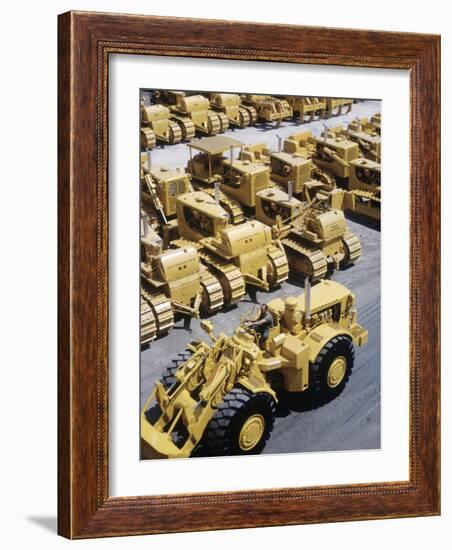 Rows of Brightly Colored Caterpillar Bulldozers Lined up at an Unidentified Factory-John Zimmerman-Framed Photographic Print