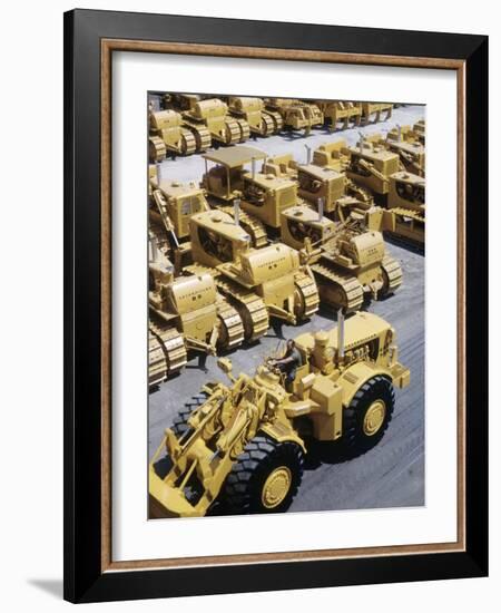Rows of Brightly Colored Caterpillar Bulldozers Lined up at an Unidentified Factory-John Zimmerman-Framed Photographic Print