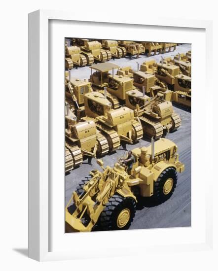 Rows of Brightly Colored Caterpillar Bulldozers Lined up at an Unidentified Factory-John Zimmerman-Framed Photographic Print