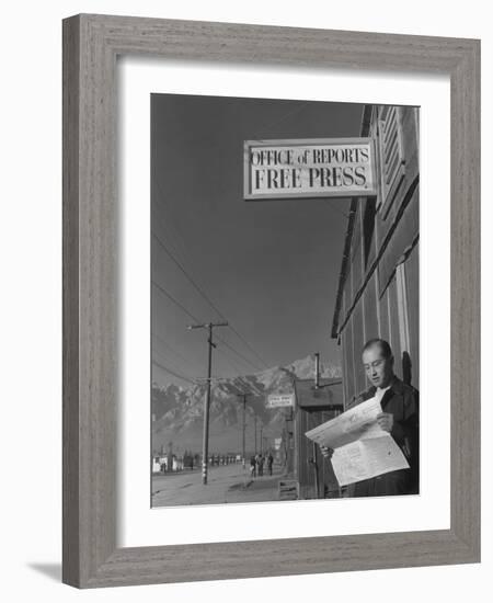 Roy Takeno, editor of Manzanar Free Press, reading the paper at the Manzanar War Relocation Center-Ansel Adams-Framed Photographic Print