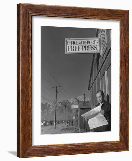 Roy Takeno, editor of Manzanar Free Press, reading the paper at the Manzanar War Relocation Center-Ansel Adams-Framed Photographic Print