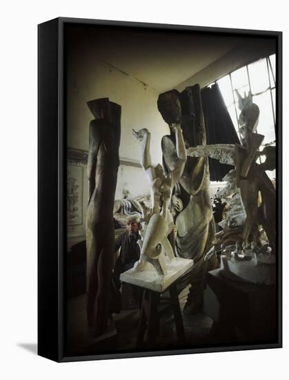 Russian Sculptor Ossip Zadkine Sitting in His Paris Studio Among Towering Sculptures-Gjon Mili-Framed Premier Image Canvas