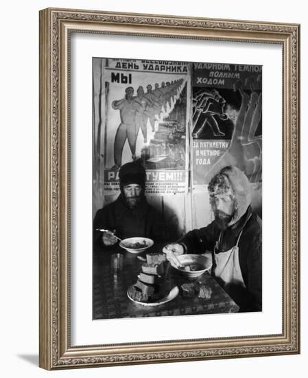 Russian Workers Eating Black Bread and Soup at Table with Soviet Communist Workers Posters, Siberia-Margaret Bourke-White-Framed Photographic Print