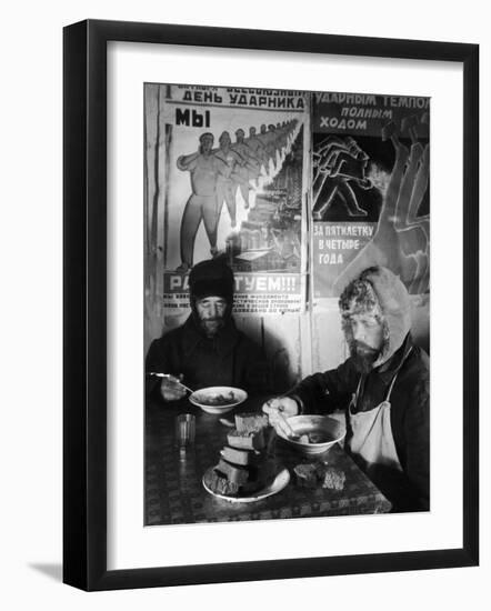 Russian Workers Eating Black Bread and Soup at Table with Soviet Communist Workers Posters, Siberia-Margaret Bourke-White-Framed Photographic Print