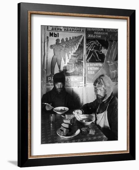 Russian Workers Eating Black Bread and Soup at Table with Soviet Communist Workers Posters, Siberia-Margaret Bourke-White-Framed Photographic Print