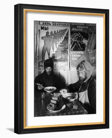 Russian Workers Eating Black Bread and Soup at Table with Soviet Communist Workers Posters, Siberia-Margaret Bourke-White-Framed Photographic Print