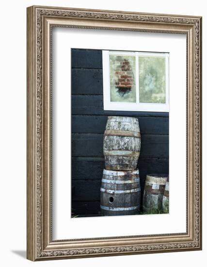 Rustic Barrels Lined Up Along an Old House Below a Window-Sheila Haddad-Framed Photographic Print