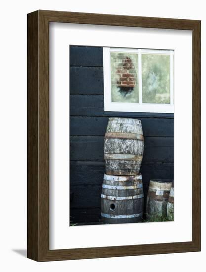 Rustic Barrels Lined Up Along an Old House Below a Window-Sheila Haddad-Framed Photographic Print