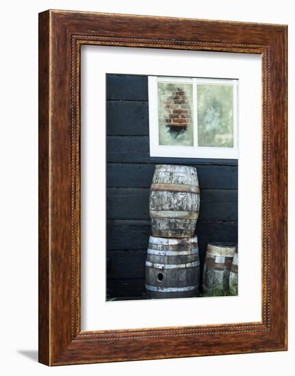 Rustic Barrels Lined Up Along an Old House Below a Window-Sheila Haddad-Framed Photographic Print