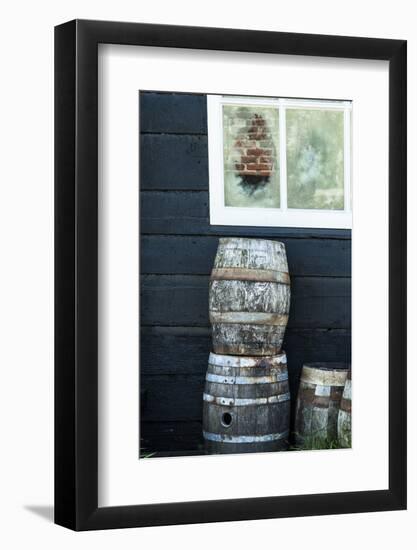 Rustic Barrels Lined Up Along an Old House Below a Window-Sheila Haddad-Framed Photographic Print