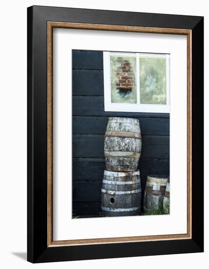 Rustic Barrels Lined Up Along an Old House Below a Window-Sheila Haddad-Framed Photographic Print