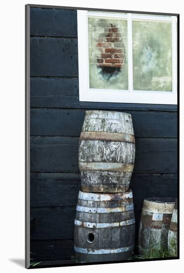 Rustic Barrels Lined Up Along an Old House Below a Window-Sheila Haddad-Mounted Photographic Print