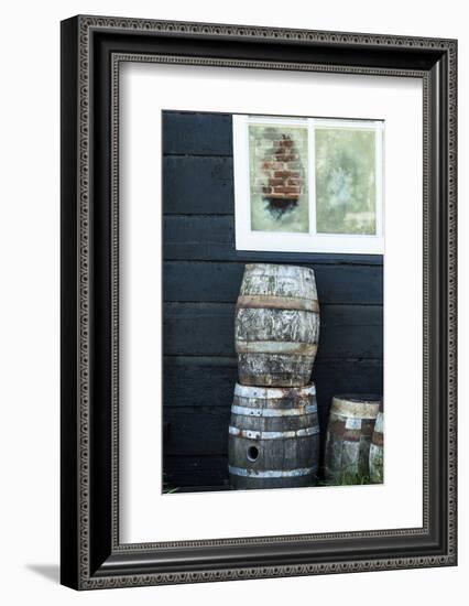 Rustic Barrels Lined Up Along an Old House Below a Window-Sheila Haddad-Framed Photographic Print