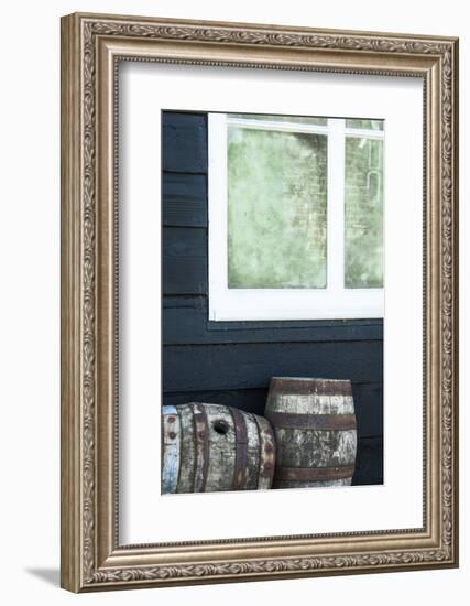 Rustic Barrels Lined Up Along an Old House Below a Window-Sheila Haddad-Framed Photographic Print