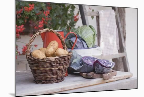 Rustic Still Life with Potatoes and Cabbage in Front of Farmhouse-Eising Studio - Food Photo and Video-Mounted Photographic Print